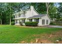 Two-story home with a balcony, brick chimney, manicured green lawn, and mature trees at 5290 River Mill Cir, Marietta, GA 30068
