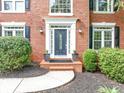 Elegant front entrance with a decorative door, white trim, and manicured landscaping at 10400 Groomsbridge Rd, Alpharetta, GA 30022