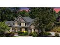 Two-story brick home with an elegant entrance, trimmed shrubbery and lush green trees at 1311 Cobblemill Nw Way, Kennesaw, GA 30152