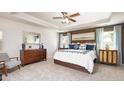 Spacious main bedroom with a tray ceiling, large windows, neutral carpeting and a decorative mirror at 1678 Lacebark Elm Way Way, Lawrenceville, GA 30045