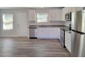 Bright kitchen features stainless steel appliances, granite counters, and white cabinetry at 80 Heyman Dr, Covington, GA 30016