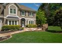 Beautiful home exterior with flagstone patio, manicured lawn, and lush landscaping at 230 Bristol Stone Ct, Johns Creek, GA 30005