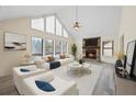 Bright living room featuring vaulted ceilings, large windows, fireplace, and modern decor creating a cozy atmosphere at 3032 Ross Rd, Snellville, GA 30039