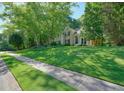A spacious home with a lush green lawn and mature trees, creating a serene setting at 1328 Amberwood Dr, Woodstock, GA 30189