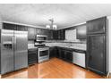 Kitchen featuring wood floors, stainless steel appliances, granite countertops and black cabinets at 1822 Oriole Trl, Lithia Springs, GA 30122