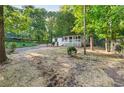 Exterior view showcasing lush landscaping, including a covered front porch and a tree-lined backdrop, exuding curb appeal at 4212 Bryan Se Dr, Acworth, GA 30102