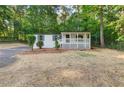 Exterior view of a home featuring a covered porch, complemented by well-maintained landscaping and an abundant tree line at 4212 Bryan Se Dr, Acworth, GA 30102