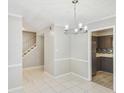 Open concept dining area with tile floors features a modern chandelier and an entrance into the kitchen at 6429 Woodstone Way, Morrow, GA 30260