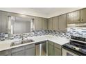 The modern kitchen includes gray cabinets, stainless steel appliances, and a stylish backsplash at 6429 Woodstone Way, Morrow, GA 30260