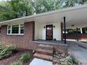 Inviting brick porch with a covered carport, offering both style and functionality to the home's facade at 224 Sourwood Dr, Marietta, GA 30062