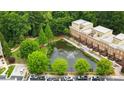 Aerial view of townhomes overlooking a serene pond with a fountain and lush greenery at 1211 Riverscall Ln, Atlanta, GA 30339