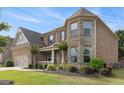 Charming two-story home featuring brick and stone exterior with lush landscaping in the front yard at 4815 Edgemoore Trce, Cumming, GA 30040