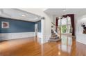 Inviting entryway featuring hardwood floors, elegant wainscoting, and a staircase with carpeted steps at 5312 Tormeal Trce, Suwanee, GA 30024