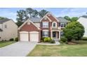 Traditional brick home with a manicured lawn, blue shutters, and a welcoming front entrance at 5312 Tormeal Trce, Suwanee, GA 30024