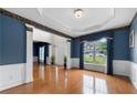 Bright living room with hardwood floors, wainscoting, and large windows with elegant drapery at 5312 Tormeal Trce, Suwanee, GA 30024