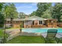 Inviting backyard with a large in-ground pool, deck, screened porch, and ample seating for outdoor relaxation at 5401 Rosser Rd, Tucker, GA 30087