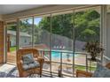Relaxing screened porch with comfortable seating, offering serene views of the pool and backyard at 5401 Rosser Rd, Tucker, GA 30087