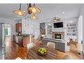 Inviting living room with a fireplace, built-in bookshelves, hardwood floors, and an open kitchen view at 611 Parkside Village Nw Way, Marietta, GA 30060