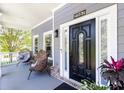 Charming front porch featuring a stylish black front door and cozy seating area, perfect for enjoying the outdoors at 2167 Tilson Rd, Decatur, GA 30032