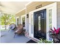 Inviting front porch with a stylish black door, decorative plants, and charming brick accents at 2167 Tilson Rd, Decatur, GA 30032