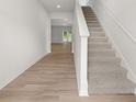 Bright hallway with wood-look flooring leading to a staircase with carpeted steps at 3036 Manor Hill Pl, Union City, GA 30291
