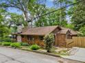 Charming bungalow featuring wood shingles, stone chimney, and a well-maintained yard at 4624 Park Dr, Pine Lake, GA 30072