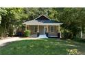 Charming home with neutral siding, covered front porch, and a well-maintained lawn and trees at 1712 Evans Sw Dr, Atlanta, GA 30310