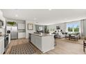 Open-concept kitchen featuring a large island, stainless steel appliances, and adjacent living area at 3038 Manor Hill Pl, Union City, GA 30291
