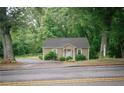 Cozy home nestled among mature trees; features a quaint facade, and is conveniently located near a road at 329 Kelly Mill Rd, Cumming, GA 30040