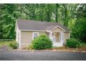 Cozy cottage-style home featuring a charming front porch and is surrounded by lush greenery and mature trees at 329 Kelly Mill Rd, Cumming, GA 30040