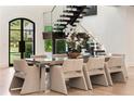 Dining room features modern table with seating for eight, staircase, and large windows offering lush views at 4132 Carmain Ne Dr, Atlanta, GA 30342