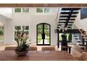 Bright entryway with a grand staircase, hardwood floors, and an arched black-trimmed front door at 4132 Carmain Ne Dr, Atlanta, GA 30342