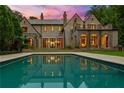 Luxury home showcasing a refreshing backyard pool that reflects the home's elegant architecture at 4560 Harris Trl, Atlanta, GA 30327