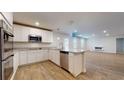 Modern kitchen featuring white cabinets, stainless steel appliances, granite countertops, and open concept to the living area at 1708 Bouquet Way, Mcdonough, GA 30253