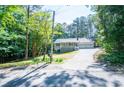 Charming home featuring a welcoming front porch, a two-car garage, and mature trees at 6026 Belle Meade Ct, Villa Rica, GA 30180