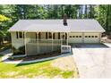 Charming home featuring a welcoming front porch, a two-car garage, and mature trees at 6026 Belle Meade Ct, Villa Rica, GA 30180