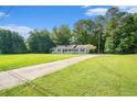 Long driveway leading up to a charming single-story home surrounded by lush greenery at 2895 Fairview Rd, Covington, GA 30016