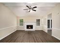 Bright living room featuring a cozy fireplace, wood-look floors, and a ceiling fan at 2895 Fairview Rd, Covington, GA 30016