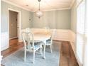 Elegant dining room with wainscoting, hardwood floors, and a stylish chandelier at 4130 Providnce Square, Alpharetta, GA 30009