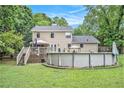 Spacious backyard featuring a deck with stairs and a round above-ground swimming pool, perfect for outdoor enjoyment at 12510 Georgia 36, Covington, GA 30014