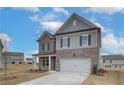 Inviting two-story home with stone and siding, a two-car garage, and landscaping in a desirable neighborhood at 408 Westmarch Cir, Loganville, GA 30052