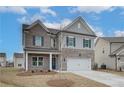 Beautiful two-story home with brick and siding, complemented by a two-car garage and a fresh young tree in the front yard at 408 Westmarch Cir, Loganville, GA 30052