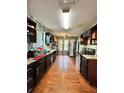 View of a long kitchen featuring granite countertops, stainless steel appliances, and wood-look flooring at 2816 Quinbery Dr, Snellville, GA 30039