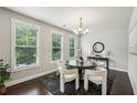 Elegant dining room with large windows, modern chandelier, and dark hardwood floors at 2817 White Oak Ln, Decatur, GA 30032