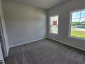 Carpeted bedroom with two windows providing ample natural light at 702 Bristol Dr, Loganville, GA 30052