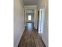 Hallway with wood floors leading to living area with natural lighting at 702 Bristol Dr, Loganville, GA 30052