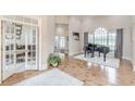 Open foyer with hardwood floors, a grand piano near arched windows, and a view into an office at 3718 Lake Vis, Douglasville, GA 30135