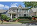 Charming two-story home with stone accents, landscaped front yard, and inviting covered porch at 595 Stonepark Ln, Suwanee, GA 30024