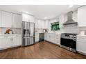 Modern white kitchen featuring stainless steel appliances, sleek countertops, and hardwood floors at 893 Vistavia Cir, Decatur, GA 30033