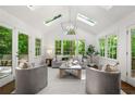 Bright and airy living room with vaulted ceiling, skylights, and a wall of windows overlooking the backyard at 893 Vistavia Cir, Decatur, GA 30033